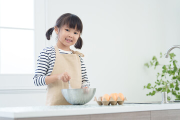 Wall Mural - キッチンで料理をする子供