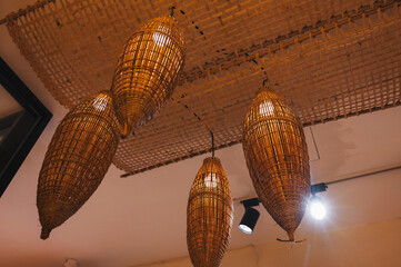 A close-up photo of bright pendant lights with a traditional woven covering of bamboo or rattan.