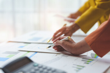 Wall Mural - Financial teamwork with marketing and accounting, professional businesswomen working together at desks, pointing out financial data in report negotiations, analysis, discussion, discussion in office.