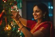 © Larisa - Woman in red sari decorating festive Christmas tree