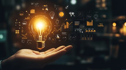 Illuminating Innovation - Hand holding lightbulb amidst business icons and graphs on black background, concept of creativity and progress.