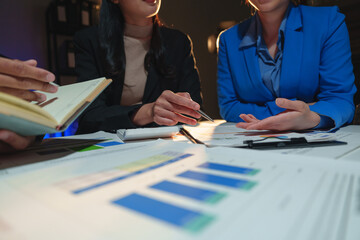 Wall Mural - Businesswoman teamwork discussing brainstorming and calculating with calculator on evaluation data in conference room Focus on business growth and point out financial accounting charts.