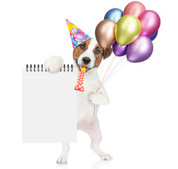 Poster - Happy jack russell terrier puppy wearing party cap holds balloons,  blows in party horn and shows blank list. Empty space for text. isolated on white background