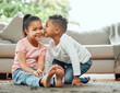 © KayJoint/peopleimages.com - Siblings, home and boy with kiss for girl on cheek with love for sister, bonding and affection for childhood embrace. Children, happy and together in living room of family house, adorable and cute.