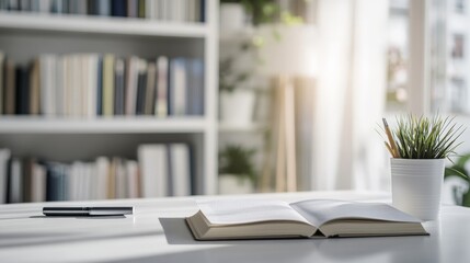 Poster - The image captures an open book on a white desk, accompanied by a black pen and a white pot with green plant, with a sunlit bookshelf in the background.