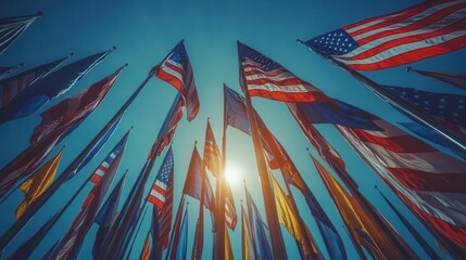 patriotic display of american flags waving against blue sky sunlight streaming through creates dynamic light and shadow celebration of national holidays and unity