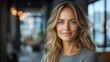 © julija - professional portrait of a confident middleaged businesswoman smiling in a modern office setting with a cityscape visible through large windows