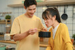 © Prathankarnpap - Happy young couple enjoying a casual meal of instant noodles together in their kitchen