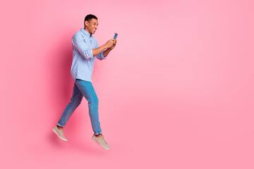 Canvas Print - Full length photo of attractive funny guy wear plaid shirt jumping texting modern gadget emtpy space isolated pink color background