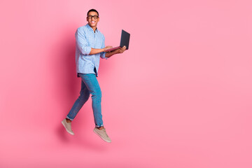 Sticker - Full length photo of cheerful positive guy dressed checkered shirt jumping texting modern device emtpy space isolated pink color background