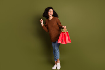 Poster - Full size photo of nice young woman bags empty space wear pullover isolated on khaki color background