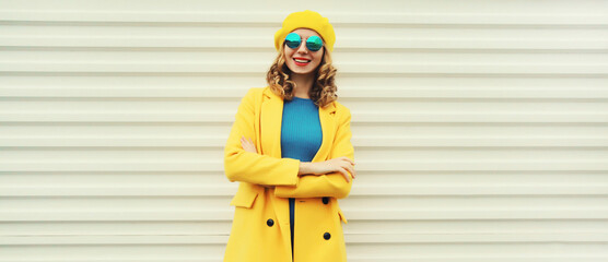 Wall Mural - Autumn portrait of beautiful happy smiling woman in yellow french hat, stylish trendy girl posing