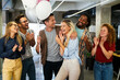 © NDABCREATIVITY - Friendly diverse employees congratulating businesswoman with business achievement