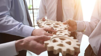 Wall Mural - Business people holding wooden gears in office