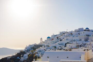 Santorini island: a beautiful panorama scenery view of Imerovigli, greek white houses and church with blue roof, sunset golden hour 