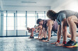 © peopleimages.com - Sports, stretching and group of people in gym for health, wellness and body workout. Team, warm up and personal trainer challenge with active routine for cardio exercise at class in fitness center