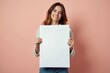 © ibhonk - Smiling Woman Holding a Blank White Sign