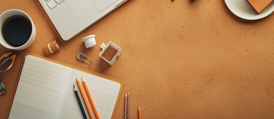 Poster - top view of a cork table featuring a blank notepad coffee cup pencils and various other items mockup