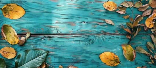 Wall Mural - Autumn leaves on the wooden aqua boards Dry yellow and green leaves with a design. Copy space image. Place for adding text and design