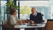 © URRMInc - An elderly man discussing financial options with a financial advisor.Financial advice for senior citizens who are not familiar with modern technology.