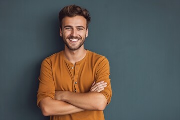 Happy caucasian man with casual clothes smiling with crossed arms. Positive person, confident, cheerful expression. Handsome young man with blond hair, beard, looking at camera with friendly, smart