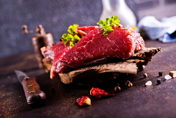 Canvas Print - Raw meat with herbs and garlic, marble meat. Wooden background. Top view.