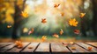 © fotofabrika - Golden autumn leaves falling gently above a wooden table in a sunlit park setting, capturing the essence of fall
