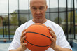 © svetlana_cherruty - Sporty man holding orange basketball ball in hand on sports court. Focus on ball. Basketball coach. Close up.