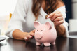 © Proxima Studio - Happy woman saving money in a piggybank