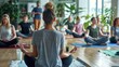 © Nany - A yoga instructor leading an office yoga class with participants engaged in mindful stretches