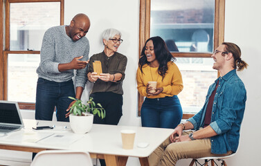 Wall Mural - Fun, colleagues and mature woman with phone, laughing and happy with collaboration, creative and project. Joke, mentor and chief editor in newsroom, people and mobile for games, staff and office