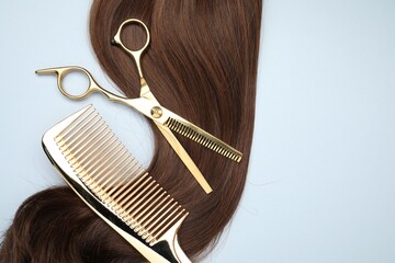 Canvas Print - Brown hair strand, comb and professional scissors on light grey background, top view