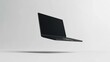 © Penatic Studio - Black Laptop Floating In Mid-Air Against A White Background