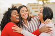 © Sabrina - Happy latin women laughing and hugging each other during travel vacation - Millennial girls and friendship concept