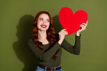 Canvas Print - Photo of shiny attractive lady dressed shirt rising big red heart looking empty space isolated green color background