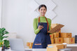 © David - Startup SME small business entrepreneur SME or freelance Asian woman calling phone, online marketing packaging box and delivery, SME concept