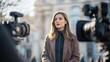 © Georgii - European female journalist reporting live on camera in an urban setting, conveying professionalism and confidence during a news broadcast.