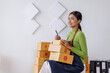 © David - SME business asian entrepreneurs small in Asia Write shipping information on a cardboard box in home office. Small business sme operators preparing to ship to customer