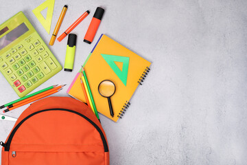 Poster - Flat lay composition with backpack and different school stationery on light grey table, space for text