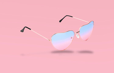 Wall Mural - Stylish sunglasses in air on pink background