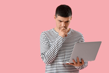 Poster - Thoughtful young man with laptop on pink  background