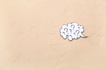 Speech bubble with question marks on beige background