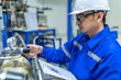 © reewungjunerr - Asian engineer working at Operating hall,Thailand people wear helmet  work,He worked with diligence and patience,she checked the valve regulator at the hydrogen tank.