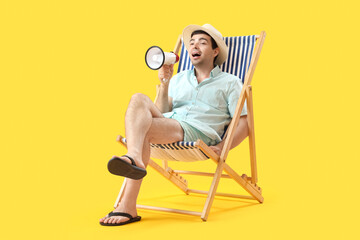 Poster - Young man with megaphone shouting in deck chair on yellow background