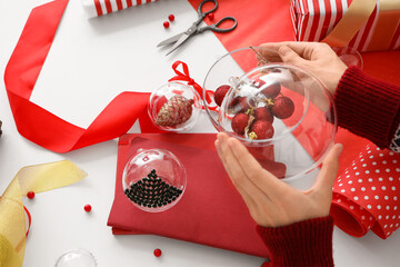 Wall Mural - Woman decorating Christmas balls on table