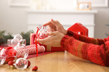 Wall Mural - Woman decorating Christmas ball with rhinestones on table