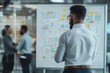 © JK_kyoto - A businessman analyzing strategic plans on a whiteboard, while colleagues discuss ideas in a modern office environment.