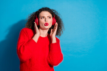 Wall Mural - Photo portrait of lovely young lady headphones look empty space dressed stylish red garment isolated on blue color background