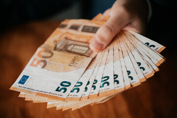 Close-up of a man holding euro banknotes in his hands