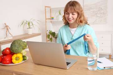 Sticker - Female nutritionist with tape measure video chatting at table in kitchen